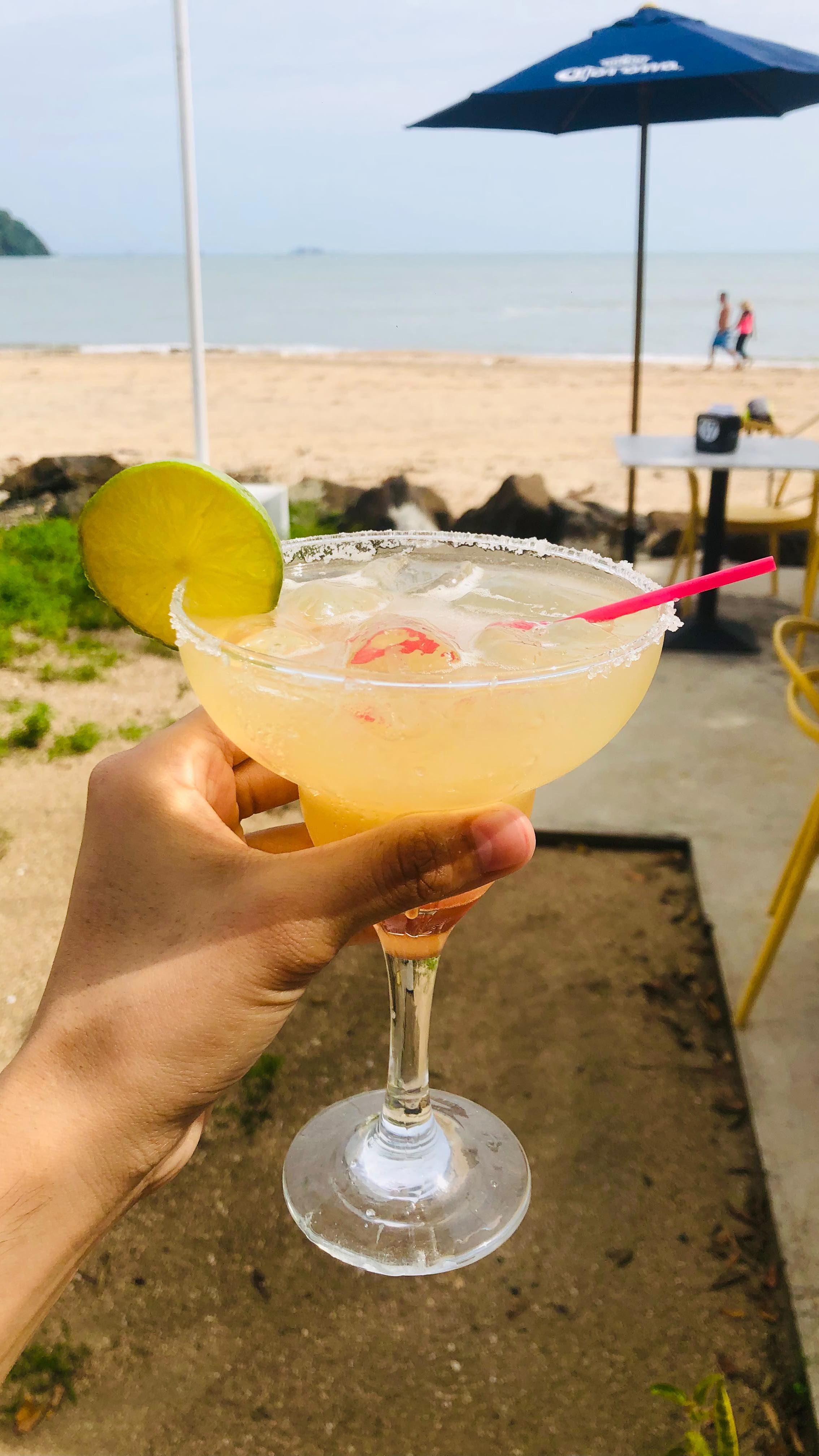 Coctel servido con la playa al fondo